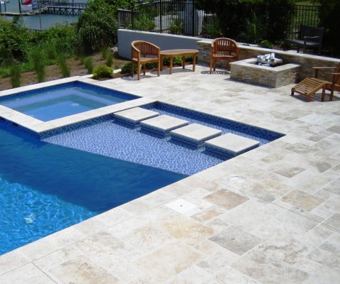 square stone firepit on travertine tile pool and spa surround patio garden