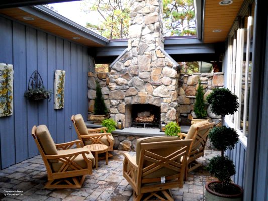 stone firpelace with a raised hearth in a courtyard outdoor room