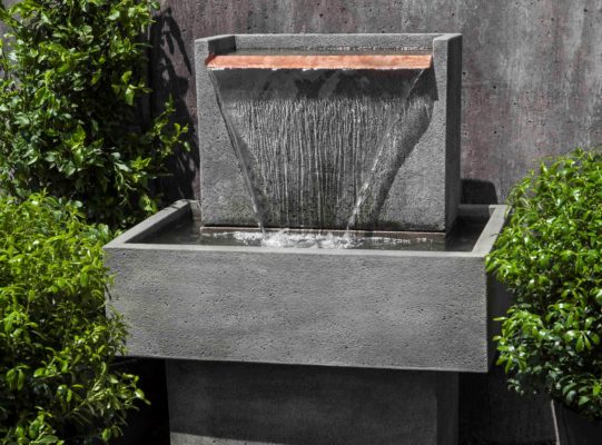 water cascading from a stone garden fountain with copper spillway