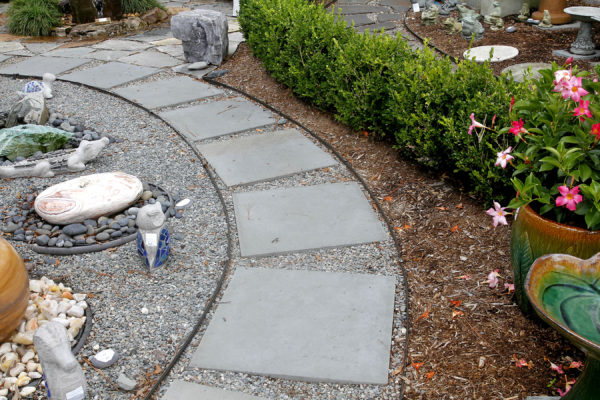 stepping stone and gravel pathway with garden art at stone garden's inspiration garden display