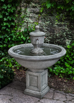 stone garden fountain with copper spillways in a garden