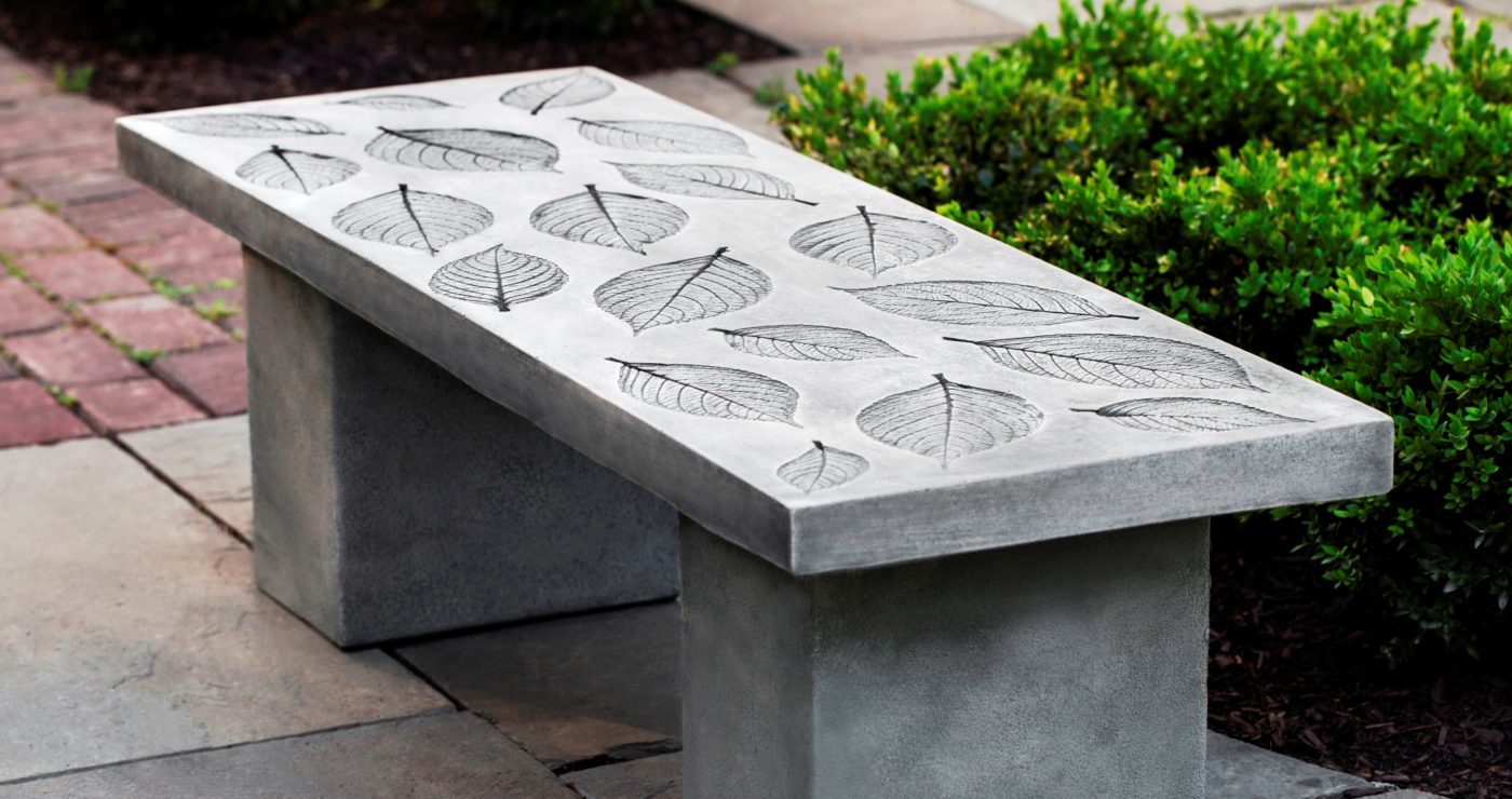 stone garden bench featuring leaf imprint pattern on stone patio