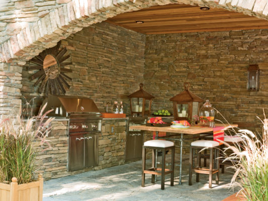 stone outdoor living kitchen and dining room patio