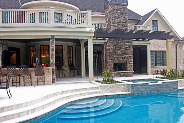outdoor living room featuring stone patio, fireplace, spa and pool