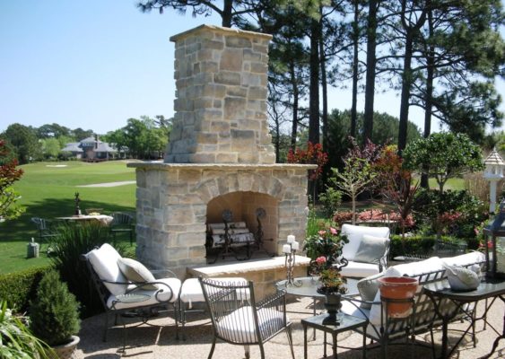 outdoor living room featuring stone patio and fireplace overlooking golf course