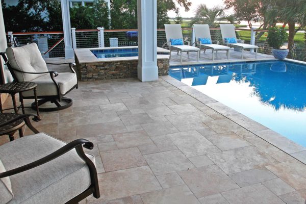 travertine tile stone pool and spa outdoor living area with lounge chairs
