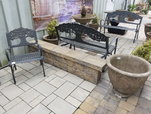 stone pavers patio, stone wall, fountain, bench, chair and plant pot at stone garden display