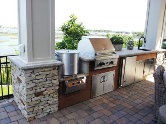 stone patio, outdoor living kitchen overlooking waterway