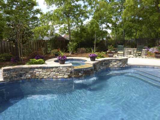 stone spa and seating wall pool surround with fire-pit outdoor living area