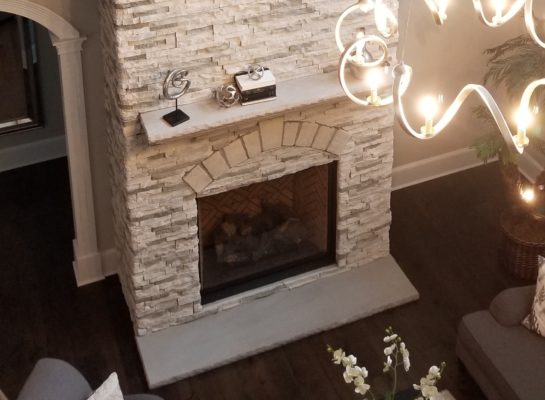 arctic white stone indoor fireplace with bluestone hearth in a living room
