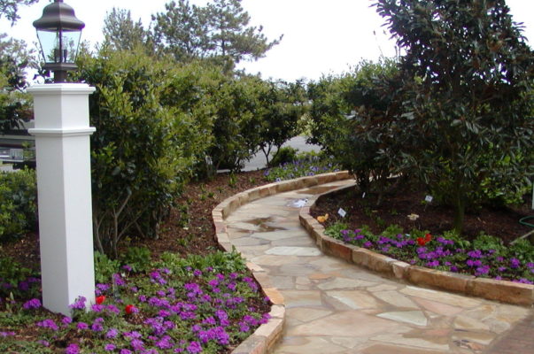 flagstone garden pathway edged in rock in colorful garden