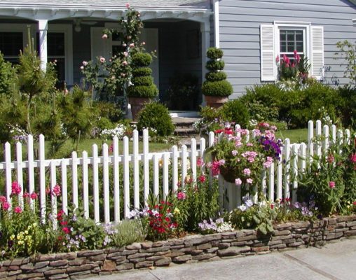 fieldstone retaining wall, stone pathway and stairs, white picket fence, garden and home