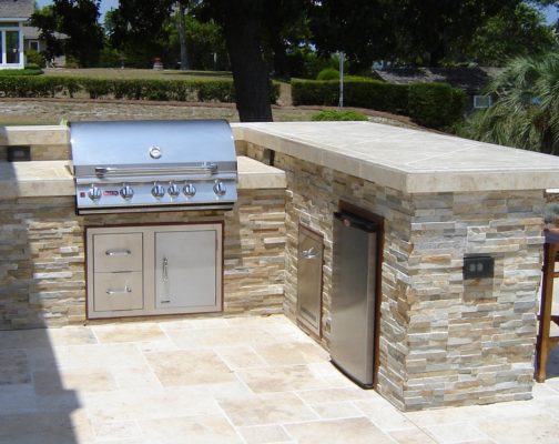 stone grill cabinet and bar in an outdoor living kitchen