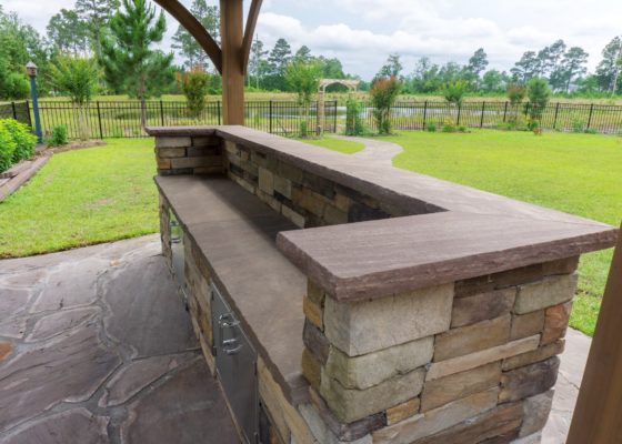 stone bar grill cabinet in a backyard garden for outdoor living