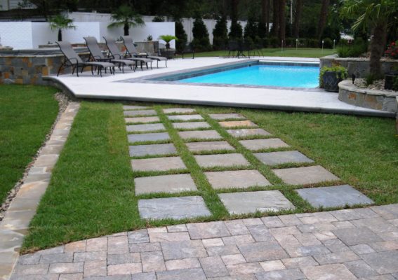 outdoor living area featuring paver patio, stone stepping stone pathway and swimming pool