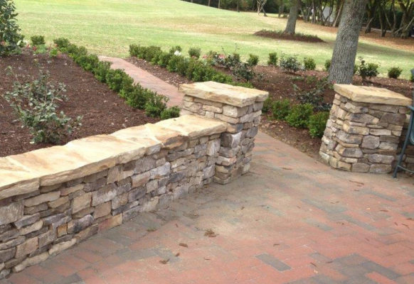 stone wall and pathway columns in a garden on a paver patio