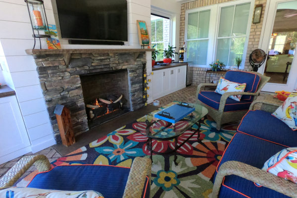 stone outdoor fireplace in a sunroom with paver patio floor