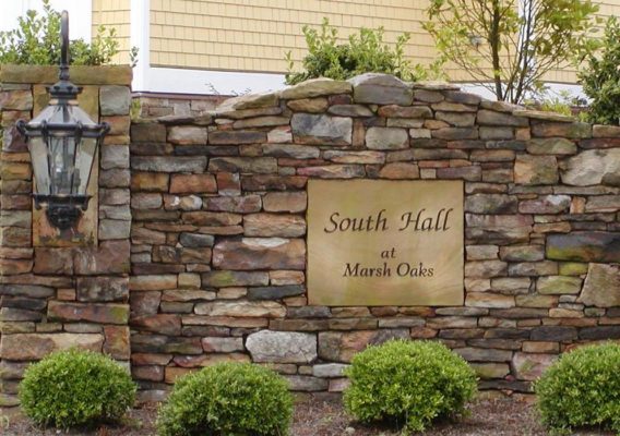 stacked stone wall featuring engraved sign for South Hall at Marsh Oaks residential community